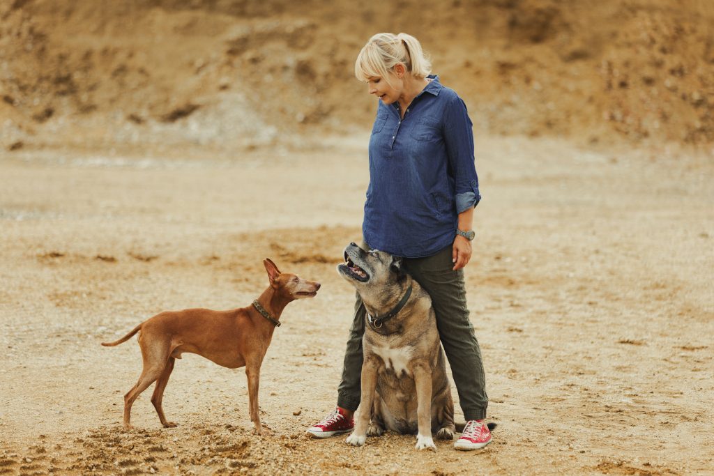 Blonde Frau mit Cane Corso und Cirneco dell'Etna